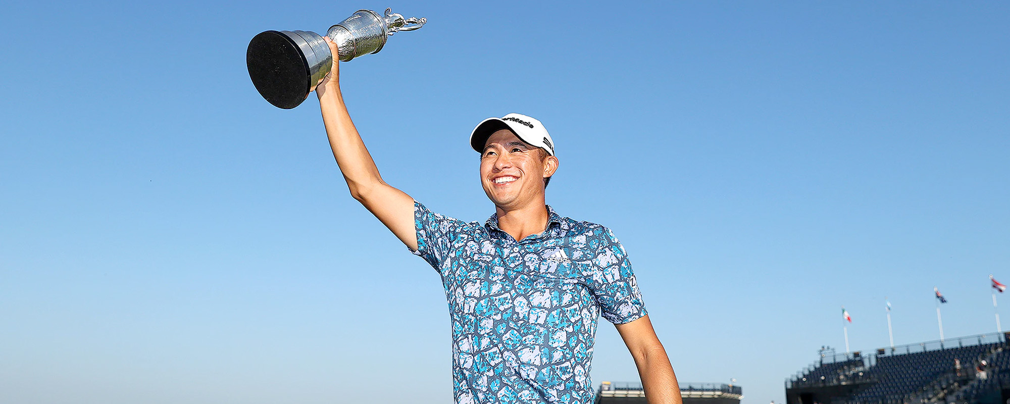 Morikawa wearing adidas cobblestone polo top with his winners trophy